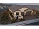 A beautiful home exterior with a two-car garage, a welcoming courtyard, desert landscaping and concrete driveway at 11900 Star Grass Ave, Las Vegas, NV 89138