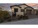 Home exterior with gated courtyard and desert landscaping, featuring a two-car garage and decorative lighting at 11900 Star Grass Ave, Las Vegas, NV 89138