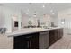 Well-lit kitchen island with a sink, stainless steel dishwasher and dark cabinetry with silver hardware at 11900 Star Grass Ave, Las Vegas, NV 89138