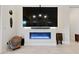 This living room showcases a modern fireplace beneath a large TV, complemented by elegant decor and lighting at 11900 Star Grass Ave, Las Vegas, NV 89138