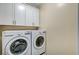 Modern laundry room includes white cabinets and newer, front-loading LG washer and dryer at 1544 Tilman Ln, Boulder City, NV 89005