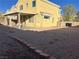 View of the yellow home exterior and the backyard with desert landscaping at 161 Lenape Heights Ave, Las Vegas, NV 89148