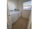 Bright laundry room with a washer, dryer, tile floor, and window at 161 Lenape Heights Ave, Las Vegas, NV 89148