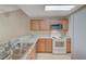 Bright kitchen boasts wood cabinets, granite countertops, and white appliances at 1800 Edmond St # 252, Las Vegas, NV 89146