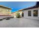 A serene backyard showcasing a stone-paved patio, a built-in seating area with fire pit, and manicured landscaping at 2124 Pont National Dr, Henderson, NV 89044