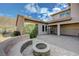 A serene backyard showcasing a stone-paved patio, a built-in seating area with fire pit, and manicured landscaping at 2124 Pont National Dr, Henderson, NV 89044