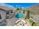 A backyard showcases a custom pool with waterfall, a fire pit area, and seamless indoor-outdoor living spaces at 2124 Pont National Dr, Henderson, NV 89044