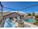 Relaxing balcony with comfortable seating and a fire pit, overlooking the pool and backyard at 2124 Pont National Dr, Henderson, NV 89044