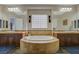 Luxurious bathroom featuring a large tub, dual sinks, and a decorative glass block window at 2124 Pont National Dr, Henderson, NV 89044