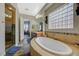 Bathroom featuring soaking tub and walk-in shower with stone tiling at 2124 Pont National Dr, Henderson, NV 89044