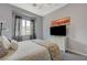 Well-lit bedroom with a ceiling fan, a television, and a beautifully decorated bed with colorful accents at 2124 Pont National Dr, Henderson, NV 89044