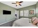 Bedroom boasting a ceiling fan, neutral walls, and tv, with an additional view to an adjacent room at 2124 Pont National Dr, Henderson, NV 89044