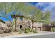 Two-story home with a tandem two-car garage, stone accents, and mature trees for shade at 2124 Pont National Dr, Henderson, NV 89044