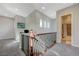 Bright upstairs hallway featuring a wooden railing and an open bathroom at 2124 Pont National Dr, Henderson, NV 89044