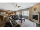 Spacious living room features a fireplace, large windows, and a dark leather sectional sofa at 2124 Pont National Dr, Henderson, NV 89044