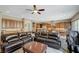 Spacious living room featuring a leather sectional, ceiling fan, and views of the modern kitchen at 2124 Pont National Dr, Henderson, NV 89044