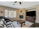 Bright living room with a fireplace, large window with pool views, and dark wood entertainment center at 2124 Pont National Dr, Henderson, NV 89044