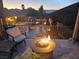 Relaxing patio with a fire pit overlooks a pool with a waterfall feature and a scenic mountain view at 2124 Pont National Dr, Henderson, NV 89044