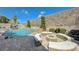 An inviting backyard pool area, complete with a fire pit and waterfall feature offers a serene outdoor space at 2124 Pont National Dr, Henderson, NV 89044