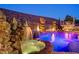 Night view of stunning pool area with rock waterfall, hot tub, and fire features creating an inviting backyard oasis at 2124 Pont National Dr, Henderson, NV 89044