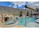 The backyard's custom pool features a rock waterfall, adjacent spa, and lush greenery, ideal for relaxation and entertainment at 2124 Pont National Dr, Henderson, NV 89044