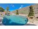 A captivating swimming pool features a built-in waterfall and slide, set against a backdrop of lush greenery at 2124 Pont National Dr, Henderson, NV 89044