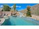 Inviting backyard pool with rock waterfall, slide, and lush landscaping, perfect for outdoor fun at 2124 Pont National Dr, Henderson, NV 89044