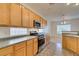 A well-lit kitchen featuring wooden cabinets, stainless steel appliances and tile floors at 2192 Tiger Links Dr, Henderson, NV 89012