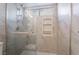 Bathroom shower with glass doors, marble-like wall, and shower head at 2244 Brighton Shore St, Las Vegas, NV 89128