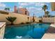 Swimming pool featuring waterfalls, stone wall, and palm trees at 2244 Brighton Shore St, Las Vegas, NV 89128