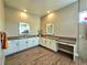 Modern bathroom with double vanity, quartz countertops, tile flooring, and mirrors at 2498 Veronella St, Henderson, NV 89044