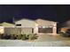 Night view of the home's facade with a two car garage and drought tolerant landscaping at 2498 Veronella St, Henderson, NV 89044