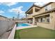 Resort-style backyard featuring a sparkling pool, putting green, and a covered outdoor kitchen at 2593 Indigo Cloud Ct, Las Vegas, NV 89142