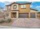 Inviting two-story home featuring a three-car garage and well-manicured desert landscaping at 2593 Indigo Cloud Ct, Las Vegas, NV 89142