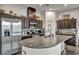 A modern kitchen featuring stainless steel appliances, dark wood cabinetry, and a granite countertop island with sink at 2593 Indigo Cloud Ct, Las Vegas, NV 89142