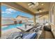 Inviting outdoor living space with comfortable seating, overlooking a stunning pool and waterfall feature at 2593 Indigo Cloud Ct, Las Vegas, NV 89142