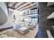 Two-story living room with wood beam ceiling, stone fireplace, spiral staircase, and gourmet kitchen at 2793 Red Arrow Dr, Las Vegas, NV 89135