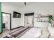 Bright bedroom featuring ensuite bathroom, TV, decorative shelving, and an open doorway at 286 Fairmeadow St, Henderson, NV 89012