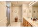 Bathroom showcasing double sinks, a large mirror with decorative lights, and a glass-enclosed shower at 3353 Kylemore St # 101, Las Vegas, NV 89129