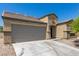 Tan house with a gray garage door and a small yard at 3357 Sheep Canyon St, Las Vegas, NV 89122