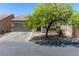 Tan house with a gray garage door and a tree in front at 3357 Sheep Canyon St, Las Vegas, NV 89122