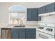 Kitchen features blue cabinets and stainless steel appliances at 3357 Sheep Canyon St, Las Vegas, NV 89122