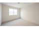 Clean and simple bedroom space with neutral walls, carpet, and a large window at 353 Keating St, Henderson, NV 89074