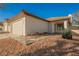 Single-story home with a two-car garage, low-maintenance landscaping, and a desert-style yard at 353 Keating St, Henderson, NV 89074