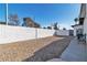 This backyard features a gravel area enclosed by a tall white block wall for added privacy at 3700 San Angelo Ave, Las Vegas, NV 89102