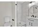 Bathroom featuring sleek white fixtures, a walk-in shower, and a modern round mirror at 3700 San Angelo Ave, Las Vegas, NV 89102