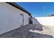 Exterior view of a home with a white painted facade, black trim, and a gated entrance to the backyard at 3700 San Angelo Ave, Las Vegas, NV 89102