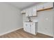 A kitchenette with white cabinets and hardware, a stainless sink, and light wood floors at 3700 San Angelo Ave, Las Vegas, NV 89102