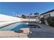 A backyard featuring a private pool with a spa, surrounded by a concrete patio and a white brick fence at 3700 San Angelo Ave, Las Vegas, NV 89102