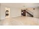 Spacious living room featuring tile flooring, staircase, and access to kitchen and laundry room at 3932 Voxna St, Las Vegas, NV 89119